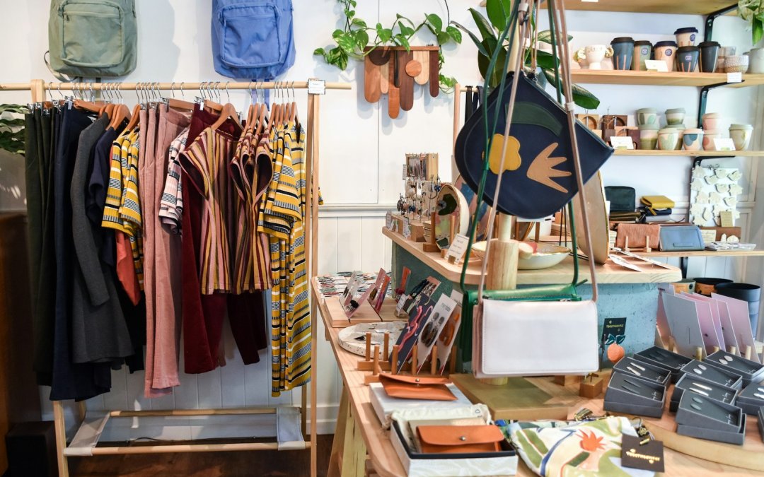 assorted-colored clothes on rack near brown wooden table