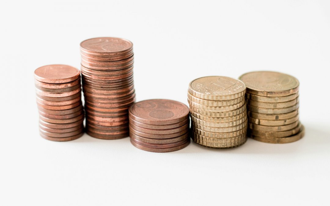 stacked round gold-colored coins on white surface